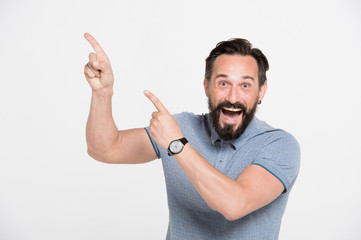 Cheerful bearded man pointing to the upper left part of the photo
