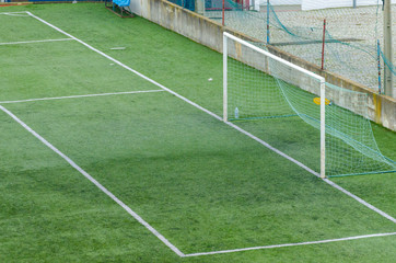 Detalle de la porteria y del area de un campo de futbol de hierba artificial. 
