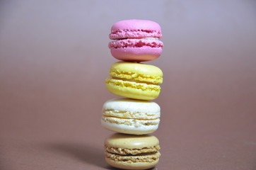 Colourful tasty macaroons in a row. macaroons of different colors on a brown background