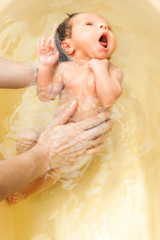 Fototapeta premium Small nwborn big-eyed beautiful baby bathes