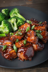 teriyaki chicken and broccoli on black plate