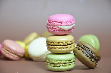 Colourful tasty macaroons in a row. macaroons of different colors on a brown background