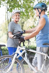 Naklejka premium Senior bicycle rider looking at senior man in park
