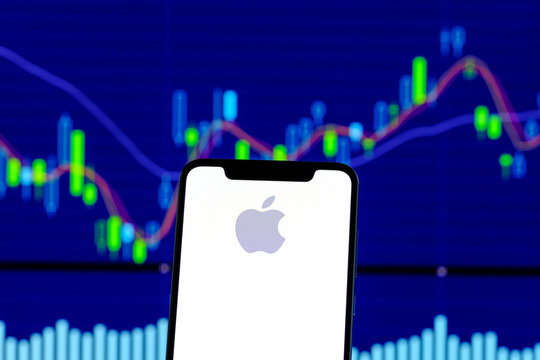 Apple logo is seen on an smartphone over stock chart
