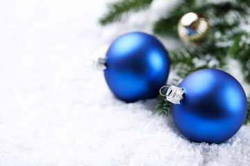 Fototapeta na wymiar Christmas baubles with fir tree branches on white snow