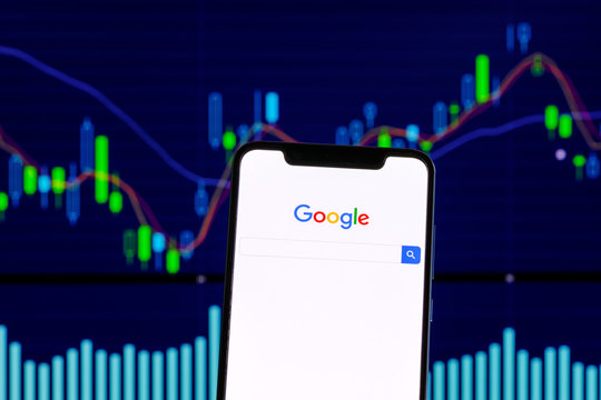 Google logo is seen on an smartphone over stock chart