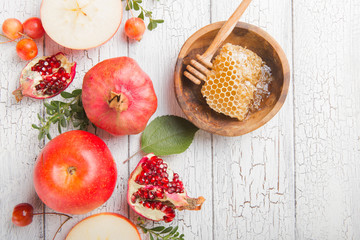 Rosh hashanah - jewish New Year holiday concept. Traditional symbols: Honey jar and fresh apples with pomegranate and shofar -horn on a white background. Copy space for text. View from above