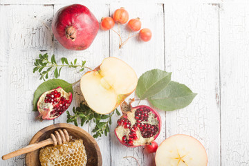 Rosh hashanah - jewish New Year holiday concept. Traditional symbols: Honey jar and fresh apples with pomegranate and shofar -horn on a white background. Copy space for text. View from above