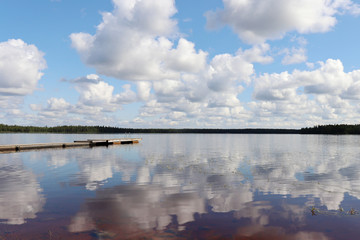 Dock and cloud reflection at a lake in Ranua, Finland
