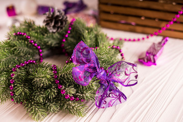 Christmas wreath decoration with festive decor. Made by hands on a wooden white background.