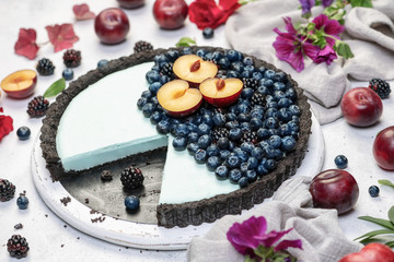 fresh blueberry tart with fruits on white conrete background