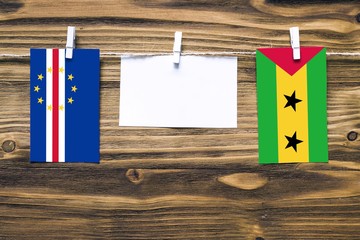 Hanging flags of Cape Verde and Sao Tome And Principe attached to rope with clothes pins with copy...
