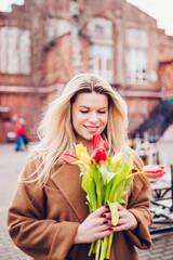 Happy successful lovely blonde girl on a date with flowers from a man