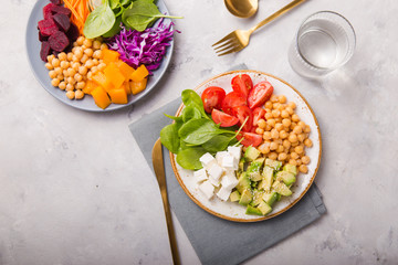 Two plates Buddha Bowls  and glass of water. Concept for  healthy vegetarian detox balanced  meal. Top view. Copy space.