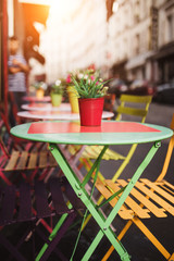Multi-colored table of a street cafe with a perspective view of the street