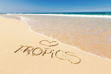 Inscription Tropics on sandy beach