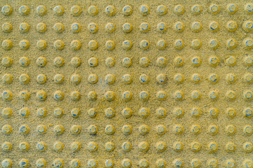 Texture of concrete yellow tiles with round bulges on train station for Blinds Handicap. Yellow...