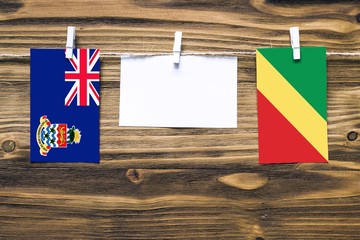 Hanging flags of Cayman Islands and Republic Of The Congo attached to rope with clothes pins with...