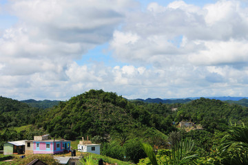 Looking out over the hills and the houses, Nine Mile, Jamaica. Houses are nestled among the dense tropical foliage the covers the mountains.