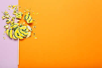 Broken lollipop candy on colorful background