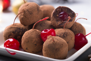 Christmas Sweet candies on the dessert table . Chocolate Balls of biscuit with cherry - loli pop or cake pop. New year decoration and apple cider drink. happy holidey concept