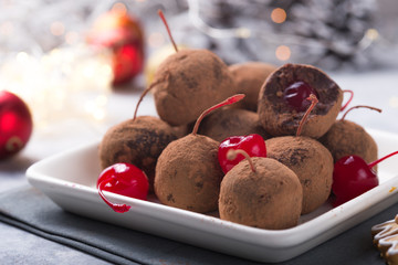 Christmas Sweet candies on the dessert table . Chocolate Balls of biscuit with cherry - loli pop or cake pop. New year decoration and apple cider drink. happy holidey concept
