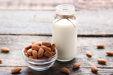 Almond milk in bottle on grey wooden table