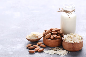 Almond and milk in bottle on grey wooden table