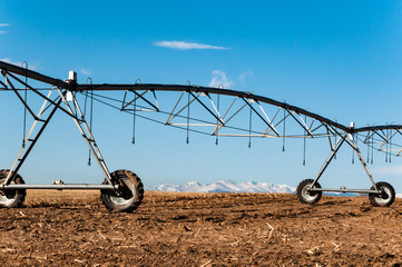 Irrigation sprinkler sits on the field after the harvest.