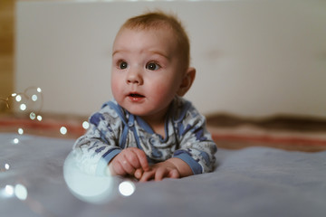 the kid, with his eyes wide open, looks into the distance. lies on the tummy