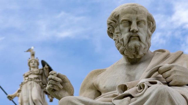 classic statues of philosopher Plato and goddess Athena far above
