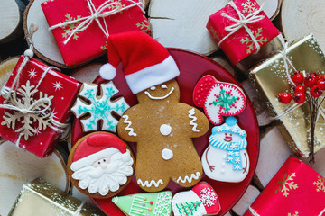 Homemade gingerbreads on plate on wooden background. Holidays and celebration concept, greeting card mockup, festive decoration. Christmas and New Year composition.