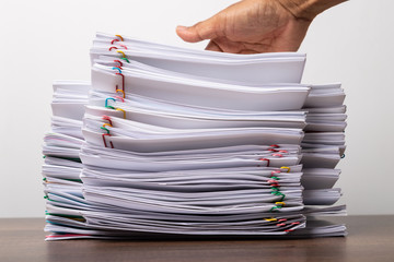Man hand on stack of over load document.