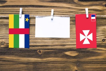 Hanging flags of Central African Republic and Wallis And Futuna attached to rope with clothes pins...