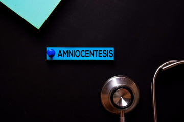 Amniocentesis text on sticky notes. Office desk background. Medical or Healthcare concept