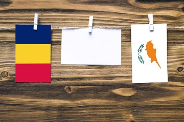 Hanging flags of Chad and Cyprus attached to rope with clothes pins with copy space on white note...