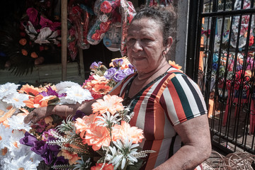 Old woman selling natural and artificial flowers for the Day of the Dead (Dia de los muertos) in Managua, Nicaragua, Central America