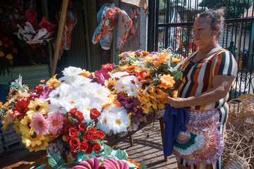 Old woman selling natural and artificial flowers for the Day of the Dead (Dia de los muertos) in...