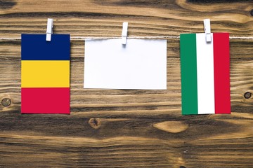 Hanging flags of Chad and Hungary attached to rope with clothes pins with copy space on white note...