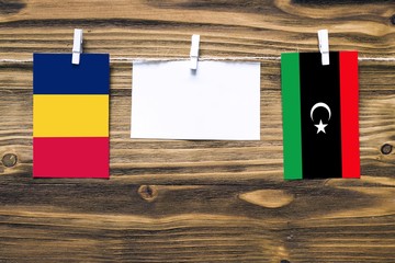 Hanging flags of Chad and Libya attached to rope with clothes pins with copy space on white note...