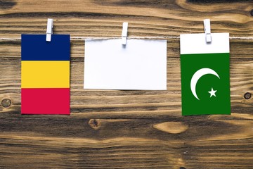 Hanging flags of Chad and Pakistan attached to rope with clothes pins with copy space on white note...