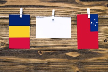 Hanging flags of Chad and Samoa attached to rope with clothes pins with copy space on white note...