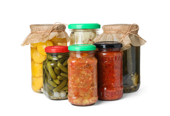 Different jars with pickled vegetables on white background