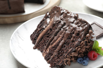 Piece of delicious chocolate cake decorated with fresh berries on white table, closeup