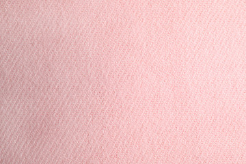 Pink knitted sweater as background, closeup view