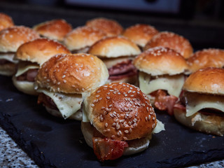 several Minicheeseburguers on black slate stone