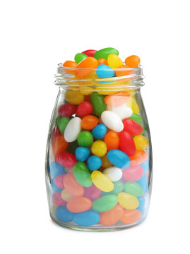 Glass jar of tasty jelly beans on white background
