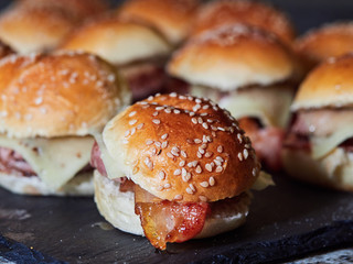 several Minicheeseburguers on black slate stone