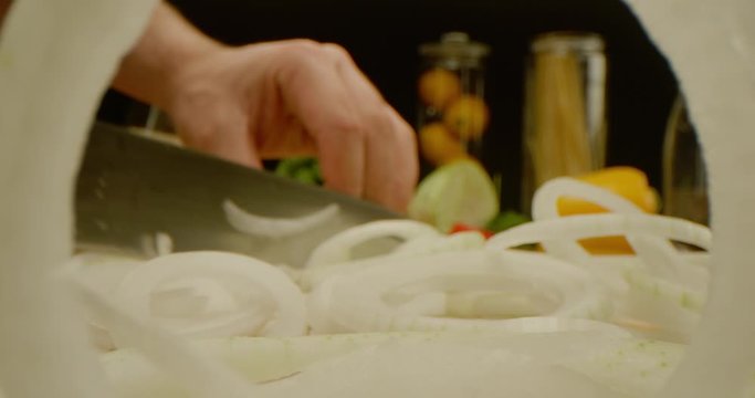 Cutting onion close up, macro shot of cooking process, kitchen stuff on a table, zooming in through onion ring, red epic,  slicing a vegetable 
