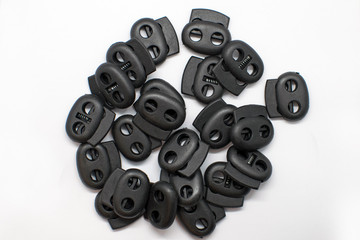 Catch clips for adjusting length and volume. Two-hole plastic retainer pig round black.